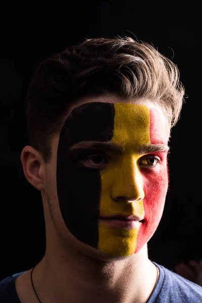 笑脸球迷支持比利时国家队在黑暗背景下被画的面孔隔绝了 — 图库照片