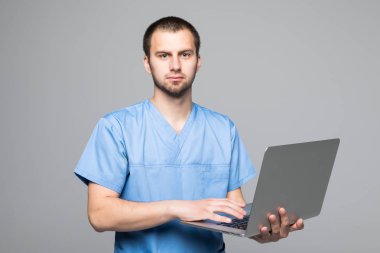 The doctor staring on the laptop isolated on gray background clipart