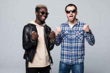 Multuracial dostluk. İki adam gri arka plan üzerinde izole kazanmak kutlamak