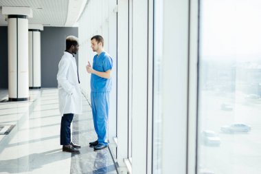 İki karışık ırk doktorlar hastanede yürürken tanı tartışıyor