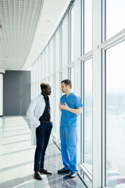 İki karışık ırk doktorlar hastanede yürürken tanı tartışıyor