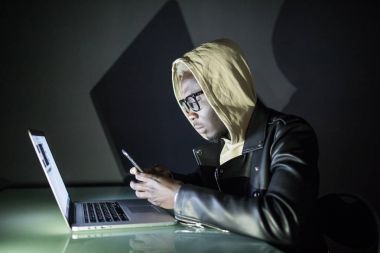 Kurban için arama ve fidye scamming için sırada veri aracılığıyla kişisel bilgilerini çalmak hareket eden smartphone kullanarak Afro Amerikan hacker.