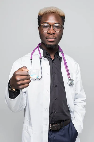 Afro-amerikai orvos tabletták tartja kezében elszigetelt szürke háttér — Stock Fotó