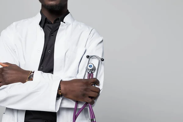 Portré, szép Afro-amerikai orvos, sthethoscope látszó-on fényképezőgép, szürke háttér elszigetelt fehér kabát — Stock Fotó
