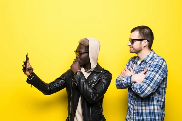 Dua sahabat baik ras campuran pria mengambil selfie pada latar belakang kuning . — Stok Foto