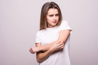 young woman with pain on her arm and shoulder on gray background. clipart