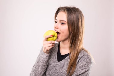 Beyaz arka plan üzerinde izole bir elma ısırma güzel güzel kız portresi kapatın