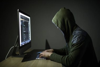 Bir hacker bir başlıklı karanlık odada bilgisayar ağları kesmek karanlık bir arka plan üzerinde