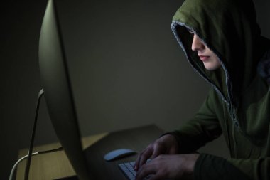 Bir hacker bir başlıklı karanlık odada bilgisayar ağları kesmek karanlık bir arka plan üzerinde