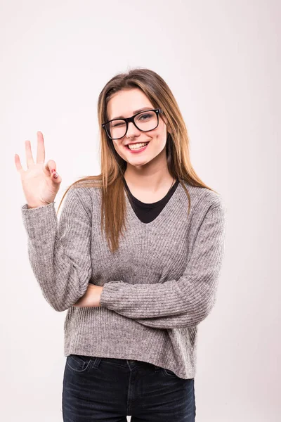 Retrato de una joven chica positiva en camisa a cuadros que muestra un gesto aceptable y guiño aislado sobre gris —  Fotos de Stock