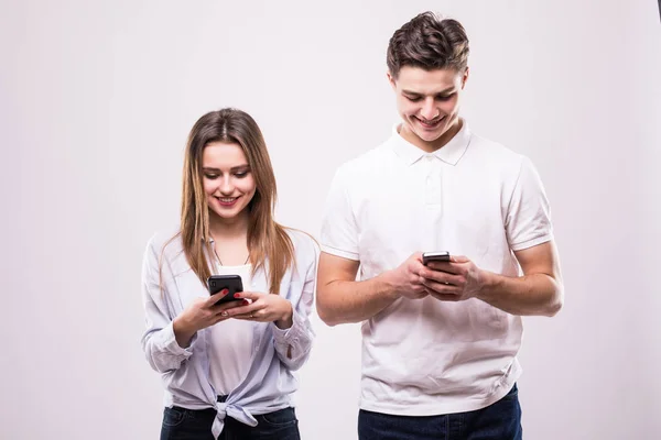 Gelukkige paar kijken naar smartphone geïsoleerd op grijs — Stockfoto