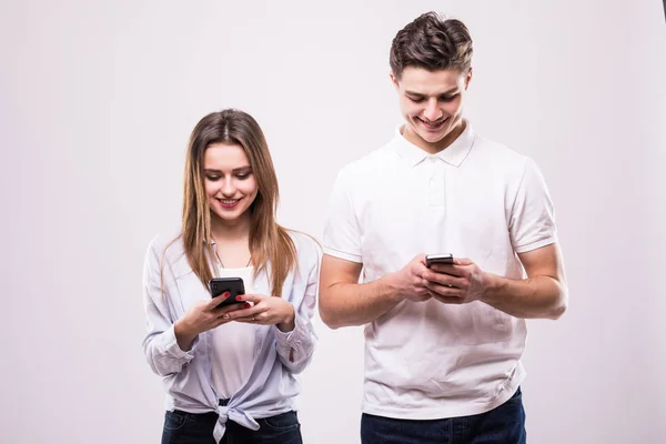 Pareja feliz mirando teléfono inteligente aislado en gris — Foto de Stock