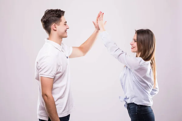 Homem e mulher alegres cumprimentando uns aos outros com um alto cinco isolados em branco — Fotografia de Stock