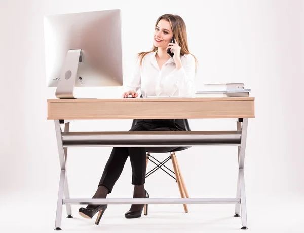 Bella giovane donna d'affari parla al telefono nel suo ufficio isolato su sfondo bianco — Foto Stock