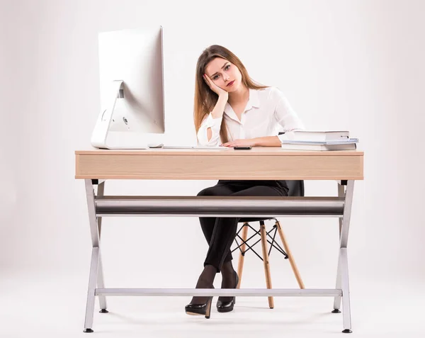 Jovem profissional estressado e cansado com dor de cabeça sentado na mesa de escritório isolado em fundo branco — Fotografia de Stock