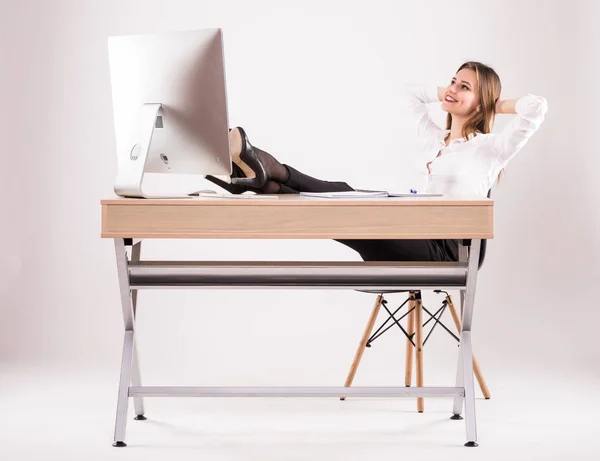 Giovane attraente donna d'affari di successo poggiando le gambe sulla scrivania isolata su bianco — Foto Stock
