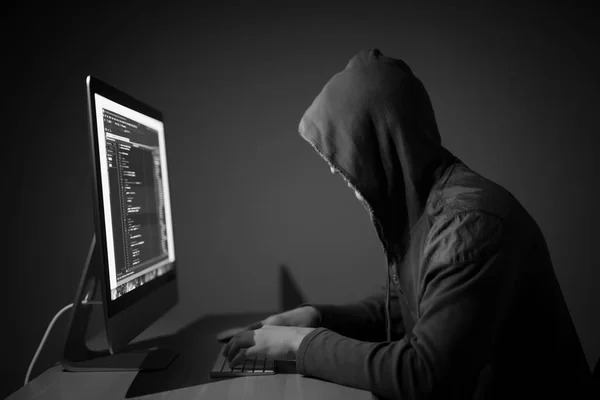 Комп'ютерний хакер в капоті працює в коді темної кімнати на ПК і зламати мережі — стокове фото