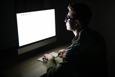 Yakışıklı erkek programcı, bu kişi, hacker, bilgisayar pc önünde karanlık odada internet üzerinde çalışır
