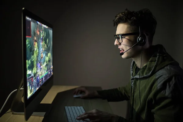 Um jogador de computador profissional joga em um computador. Vício em jogo — Fotografia de Stock