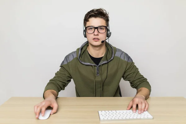 Portrait de jeune homme à table avec les mains sur le clavier et la souris. Vue de face — Photo