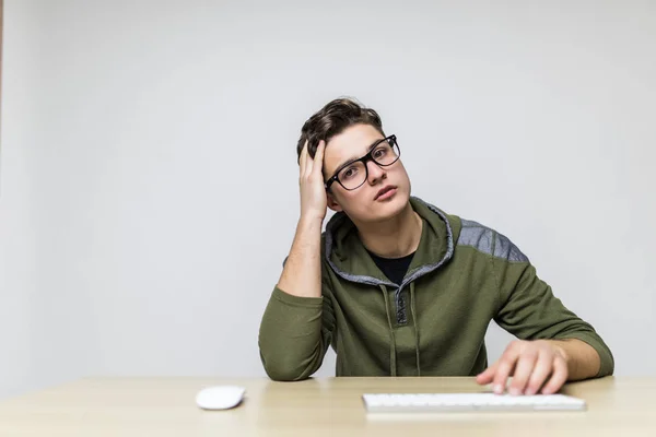 Stijlvolle knappe Kaukasische man keyboarding op computer tijdens het werken aan op nieuwe project, hebben gericht, geconcentreerd en vermoeide blik. — Stockfoto