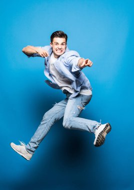 Yakışıklı adam üzerinde izole mavi arka plan atlama