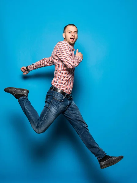 Genç casual adam mavi zemin üzerine sevinç için atlama — Stok fotoğraf