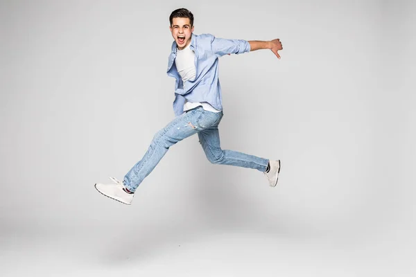 Bonito jovem pulando isolado no fundo branco — Fotografia de Stock