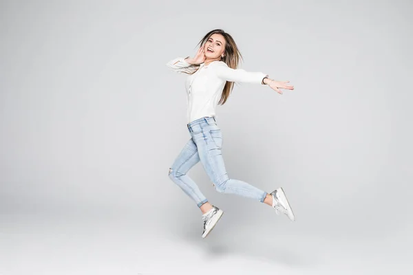 Boldogság, a szabadságon, a hatalom, a mozgás és a emberek koncepció - mosolygó fiatal nő ugrott a levegőben emelt ököllel fehér háttér — Stock Fotó