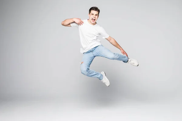 Jovem alegre pulando sobre fundo branco — Fotografia de Stock