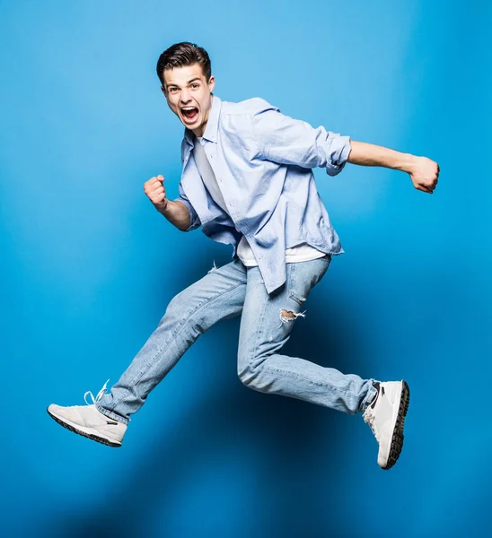 Hombre guapo saltando aislado sobre fondo azul — Foto de Stock