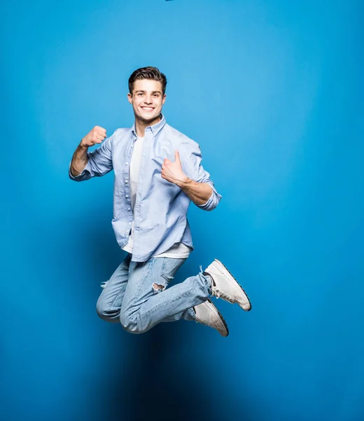잘생긴 남자가 점프에 고립 된 블루 배경 — 스톡 사진