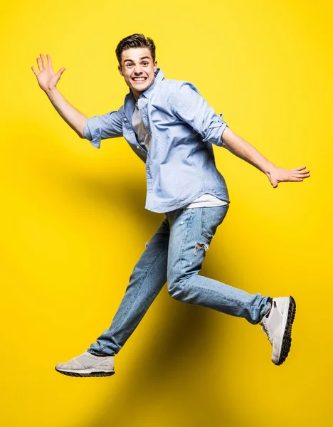 年轻英俊的男子跳上黄色的背景。跳跃, 自由, 夏天. — 图库照片