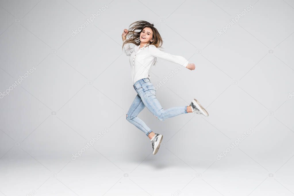 Portrait of a cheerful cute woman jumping isolated on a white background