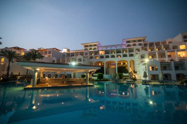 Yaz aylarında deniz ve spa Resort Yüzme havuzlu lüks otel gece aydınlatmalı günbatımı