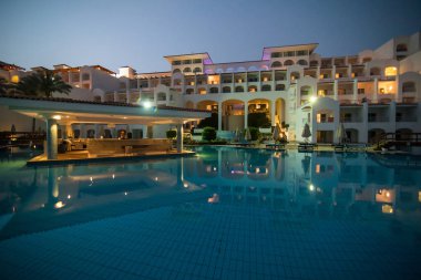 Yaz aylarında deniz ve spa Resort Yüzme havuzlu lüks otel gece aydınlatmalı günbatımı
