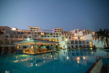 Yaz aylarında deniz ve spa Resort Yüzme havuzlu lüks otel gece aydınlatmalı günbatımı