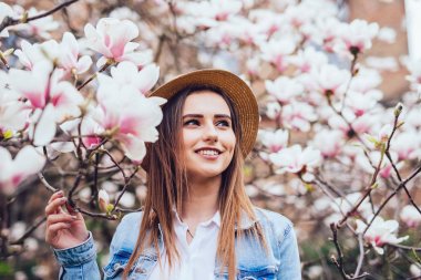 Manolya. kız ya da sevimli bayanın yakınına çiçek açması, Manolya çiçek ağaç bahar Park bahar güneşli