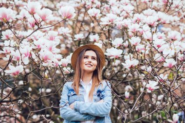 Bahar çiçeği Park Manolya ağaçları ile mutlu güzel ve genç birbayan.