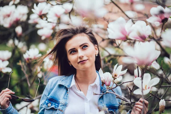 Dolce bella ragazza in piedi su sfondo morbido Magnolia fiori in fiore — Foto Stock