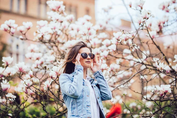 Kobieta lub dziewczyna stwarzających kwitnąca drzewo z kwiaty magnolii w spring garden w słoneczny dzień — Zdjęcie stockowe
