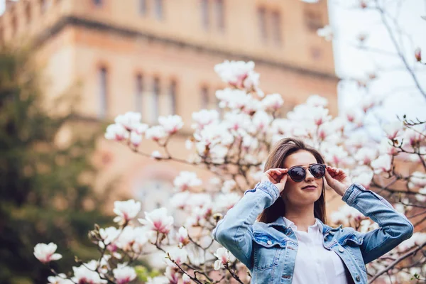 Portrait extérieur d'une jeune belle femme près d'un magnolia avec des fleurs . — Photo