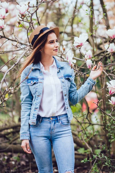 Ritratto all'aperto di una giovane bella donna vicino all'albero di magnolia con fiori . — Foto Stock