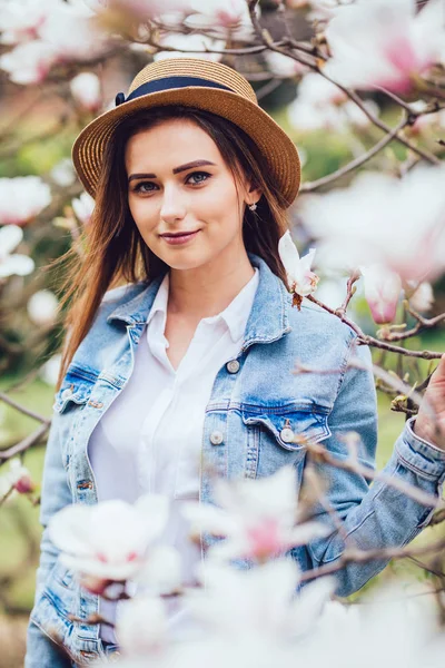 Ritratto all'aperto di giovane bella signora felice sorridente in posa vicino all'albero di magnolia fiorito . — Foto Stock