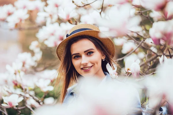 Ritratto all'aperto di giovane bella signora felice sorridente in posa vicino all'albero di magnolia fiorito . — Foto Stock