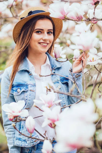 Ritratto all'aperto di una giovane bella donna vicino all'albero di magnolia con fiori . — Foto Stock