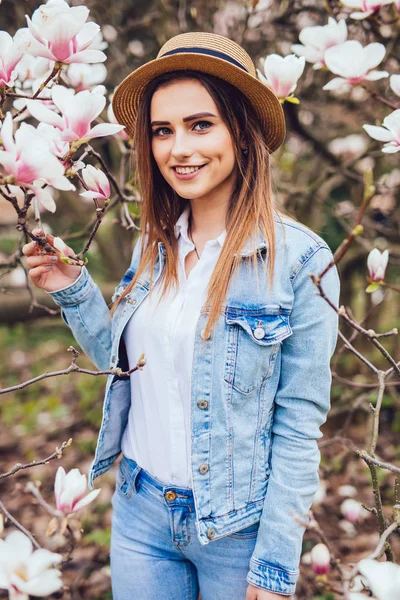 Magnolia. ragazza o donna carina vicino alla fioritura, magnolia albero dei fiori nel parco primaverile in primavera giornata di sole — Foto Stock