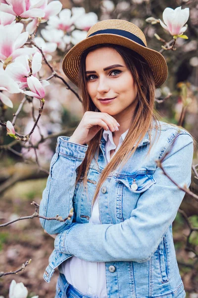 Ritratto di giovane donna che sorride nel giardino fiorito in primavera. Fiori di mandorlo fiori . — Foto Stock