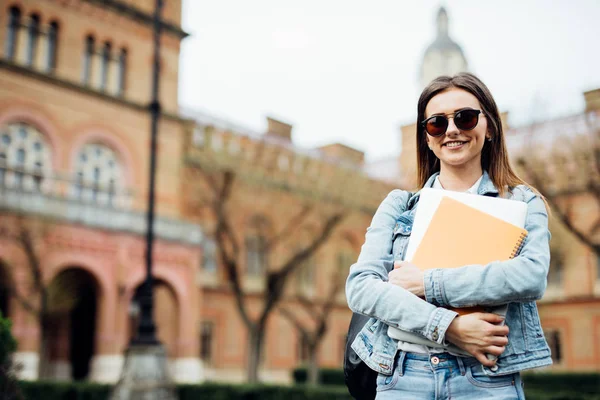 Smart junge Studentin auf dem Campus mit Notebooks in der Hand — Stockfoto