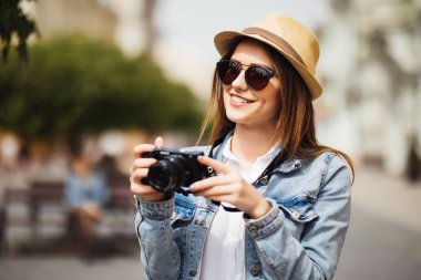 Açık yaz yaşam tarzı şehrin Avrupa'da akşam kamera seyahat fotoğraf fotoğrafçı stil gözlük ve şapka hipster içinde resim yapma ile eğleniyor genç ve güzel kadın portresi gülümseyen